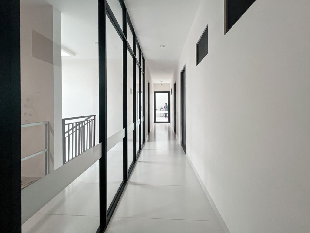 A corridor at Arcelon Premiere with glazed partitions and room doors