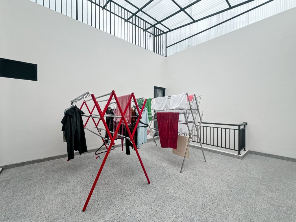 The rooftop drying area at Arcelon Premiere with clothes airers under a skylight