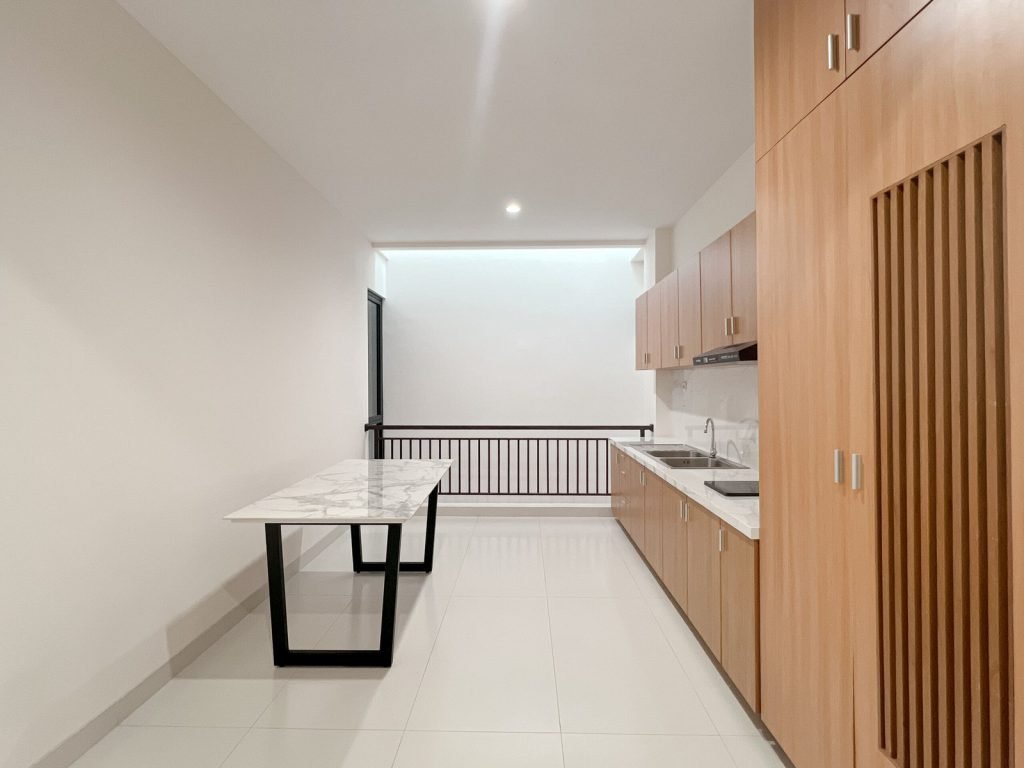 The communal kitchen at Arcelon Premiere with a marble table and full-height cabinets