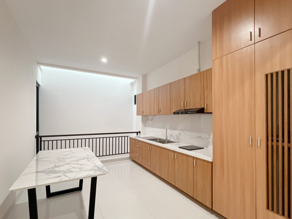 The shared kitchen at Arcelon Premiere with timber cabinetry and a marble worktop
