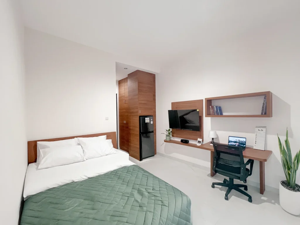 A Deluxe room at Arcelon Premiere with a bed, television, work desk and office chair