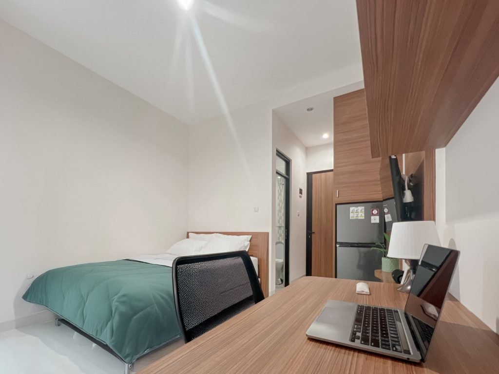 A room at Arcelon Premiere with a laptop on the work desk beside the bed