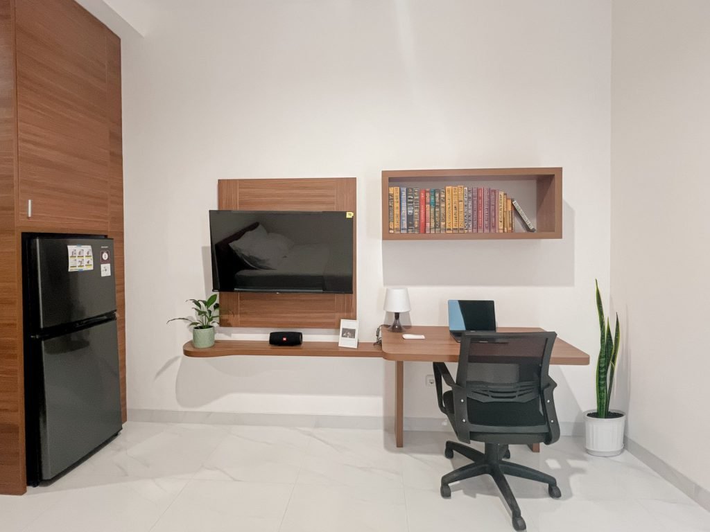 The work desk, bookshelf and television wall in a room at Arcelon Premiere