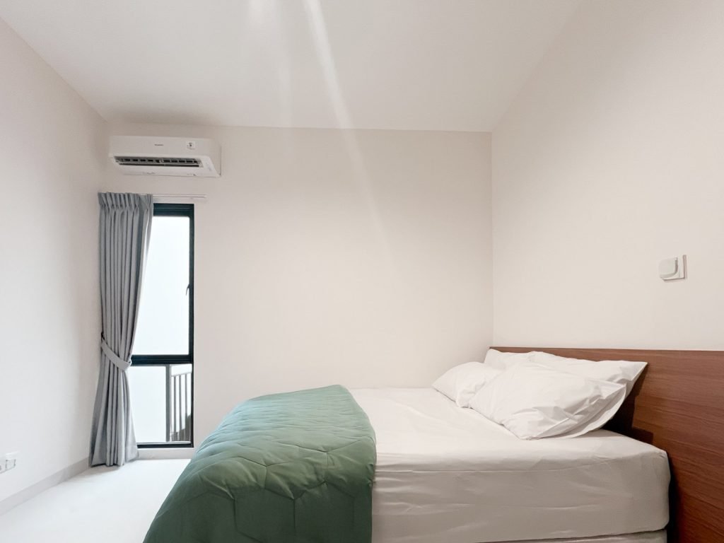 A room at Arcelon Premiere with a double bed, air conditioning and a curtained window