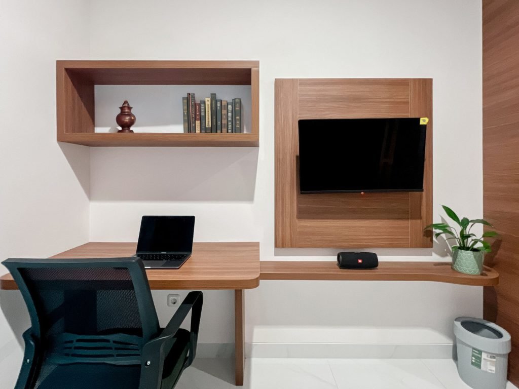 The built-in work desk, shelving and television in a room at Arcelon Premiere