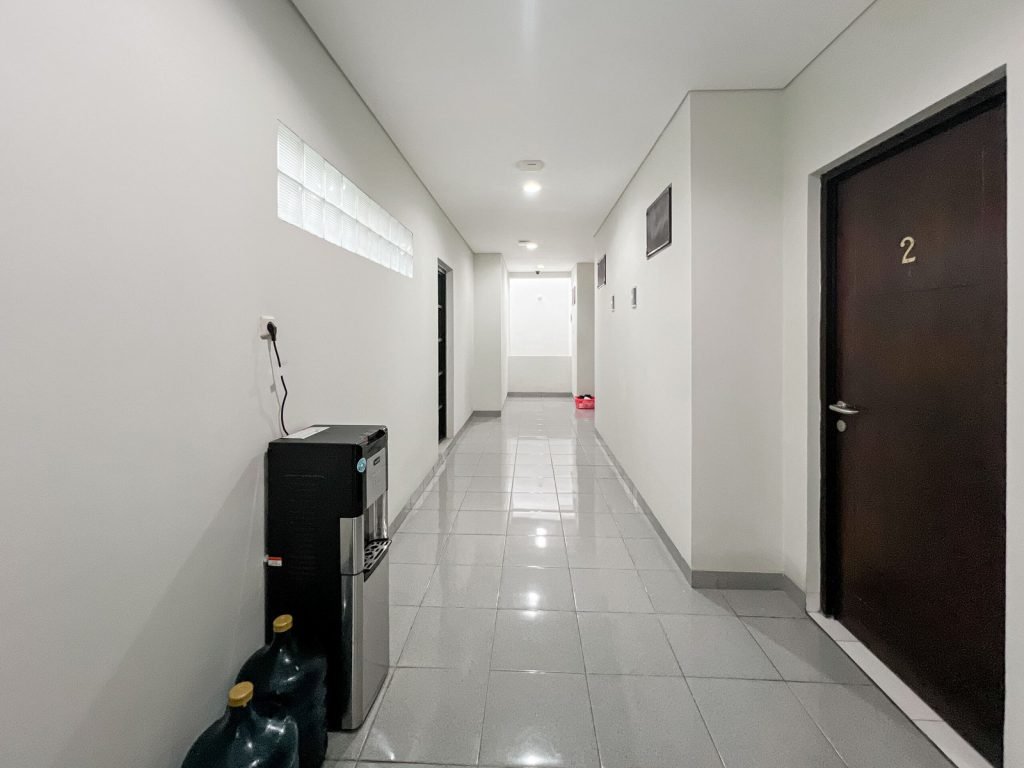 A residents corridor at Arcelon Premiere with numbered room doors and a water dispenser