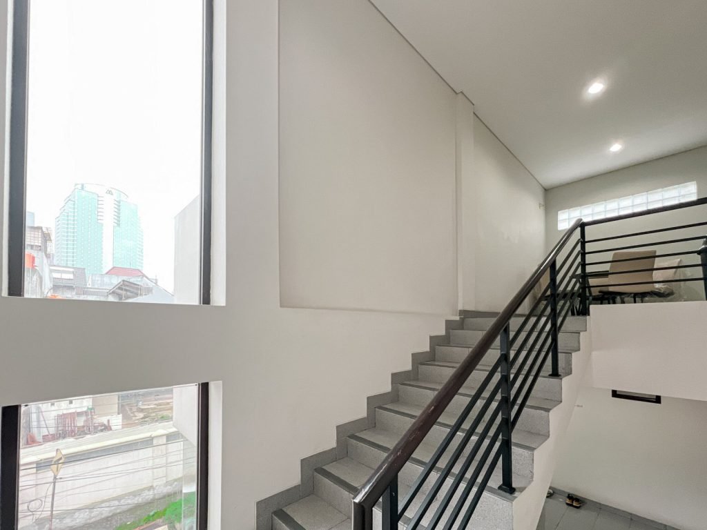 The stairwell at Arcelon Premiere with a tall window overlooking the neighbourhood