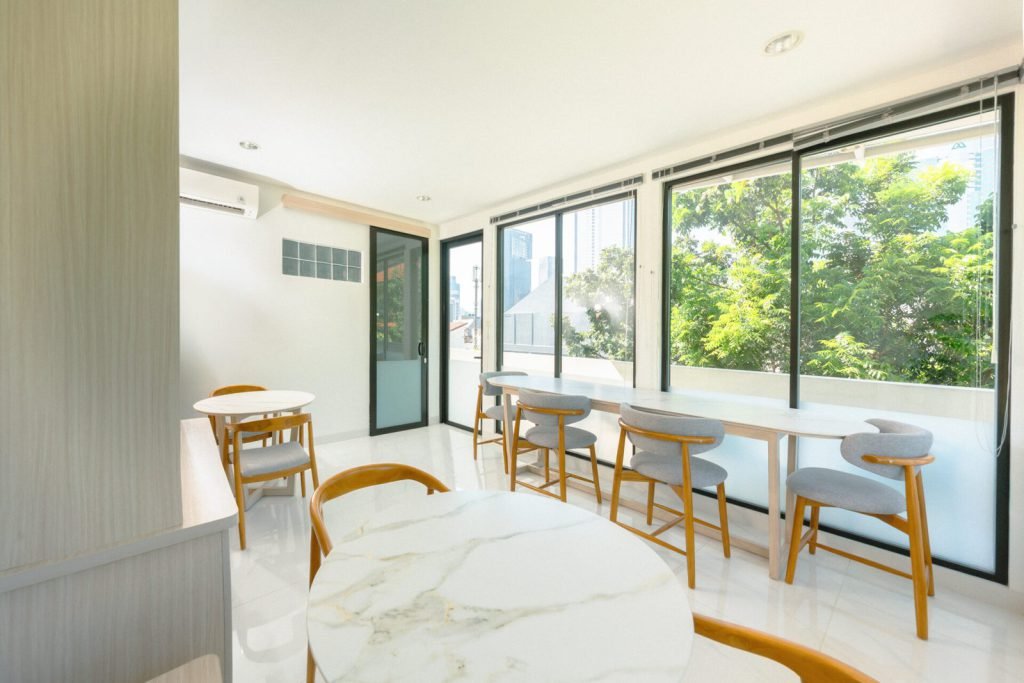 The rooftop dining area at Arcelon Executive with tables, chairs and floor-to-ceiling windows