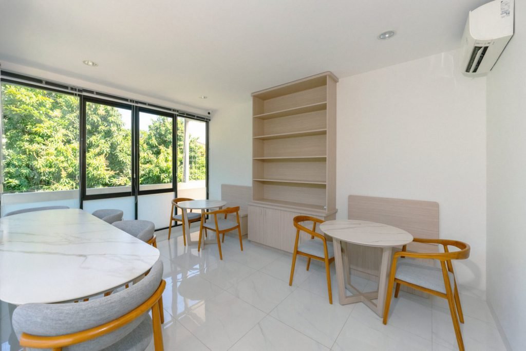 The rooftop lounge at Arcelon Executive with a marble table, timber chairs and shelving