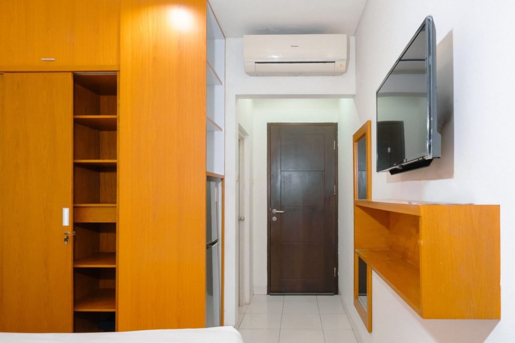 Built-in wardrobe, air conditioning and wall-mounted television in a Deluxe room at Arcelon Executive
