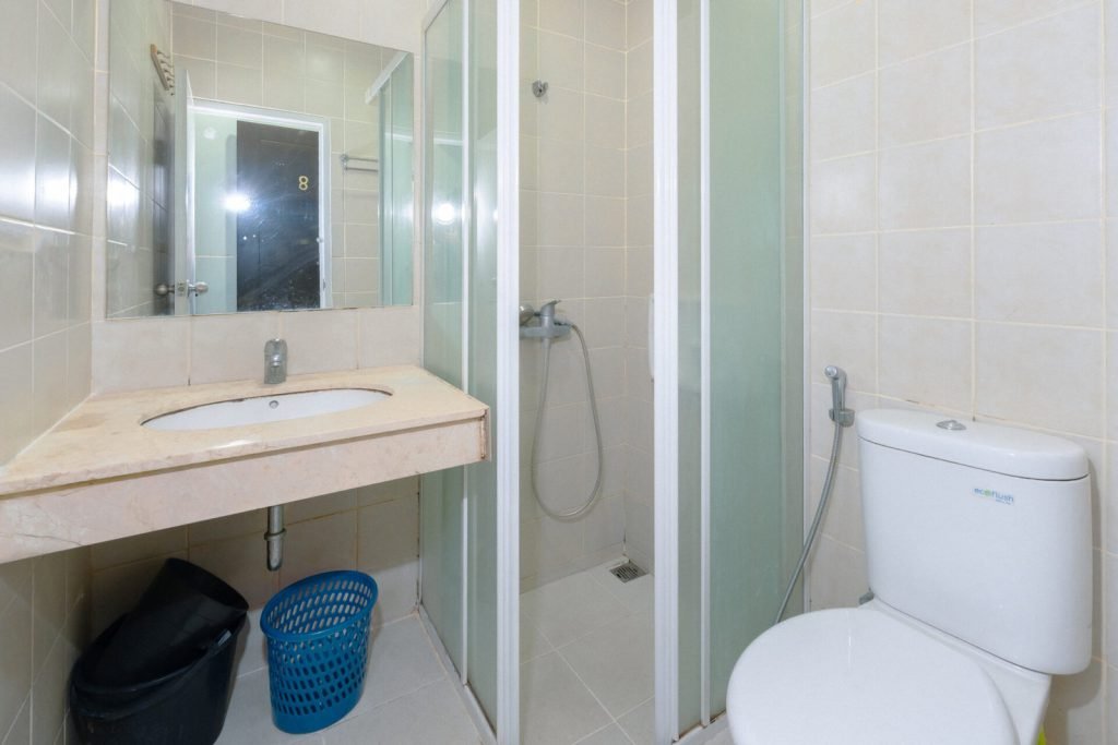 A private bathroom at Arcelon Executive with a washbowl, shower and toilet