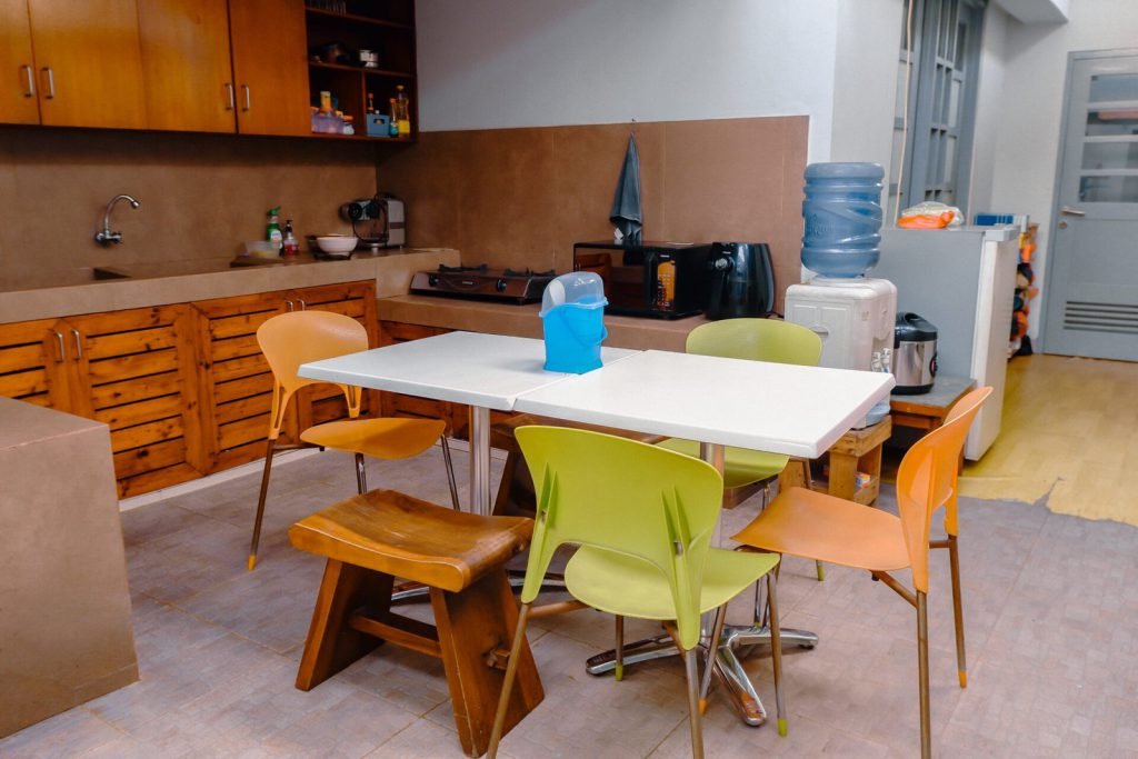 The communal kitchen and dining table at Arcelon Stay Karawaci with a water dispenser