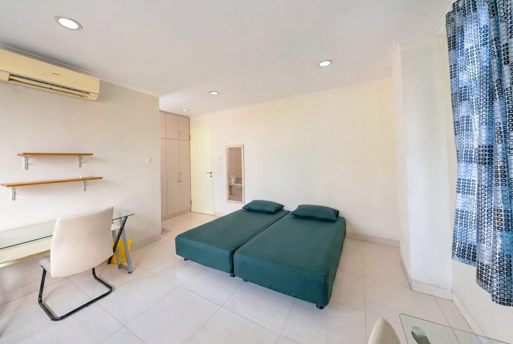 A double room at Arcelon Stay Karawaci with a bed, desk, wall shelves and air conditioning