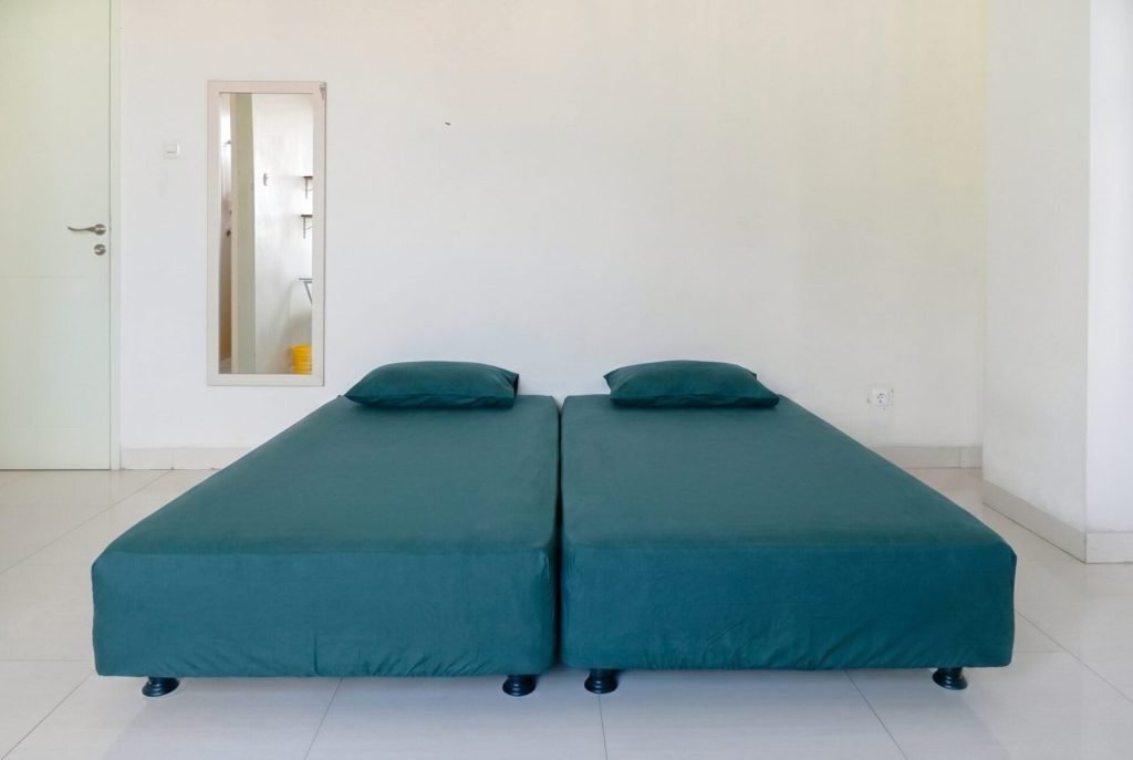 A double bed in a room at Arcelon Stay Karawaci beside a full-length mirror