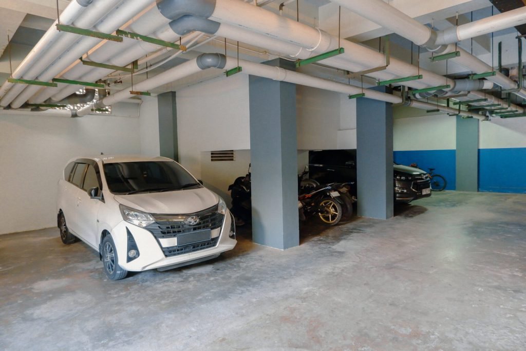 Basement car parking at Arcelon Stay Karawaci with cars and motorbikes in marked bays