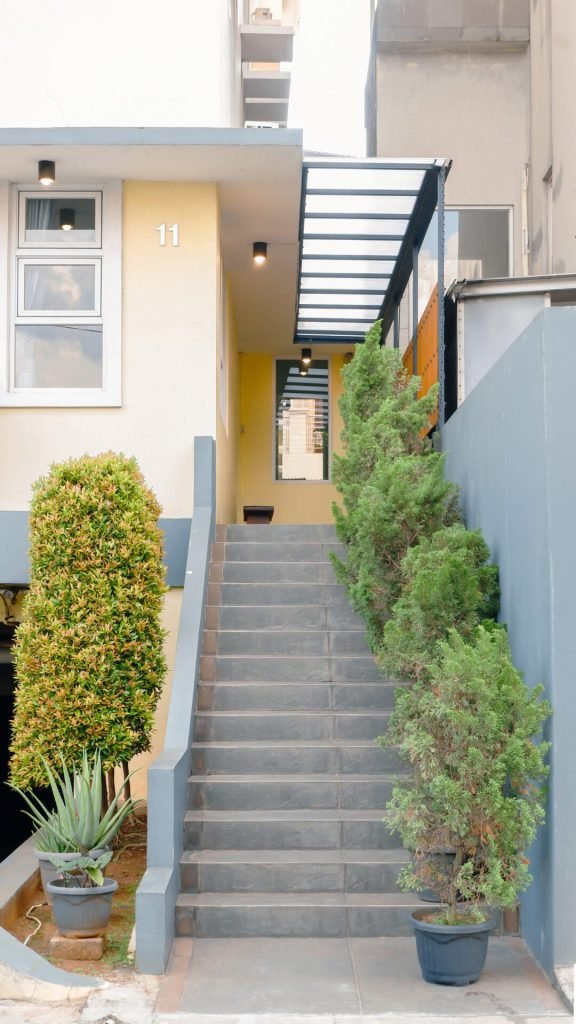 The entrance stairs to Arcelon Stay Karawaci, framed by potted plants