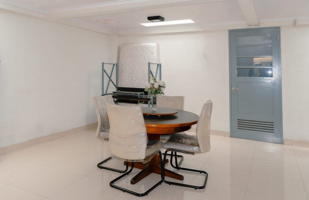 A shared meeting and dining table at Arcelon Stay Karawaci beside the service door