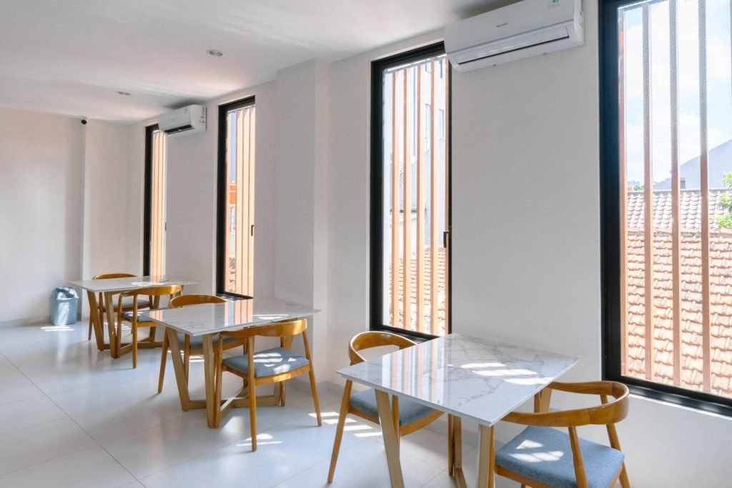The communal dining area at Arcelon Premiere with tables beside full-height windows