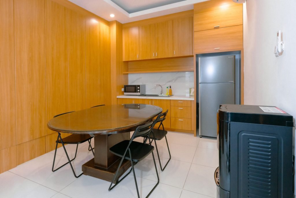 The pantry and dining table at Arcelon Premiere with a refrigerator and washing machine