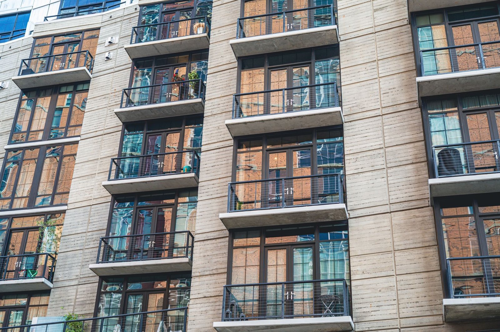 The facade of a modern apartment building with glass balconies