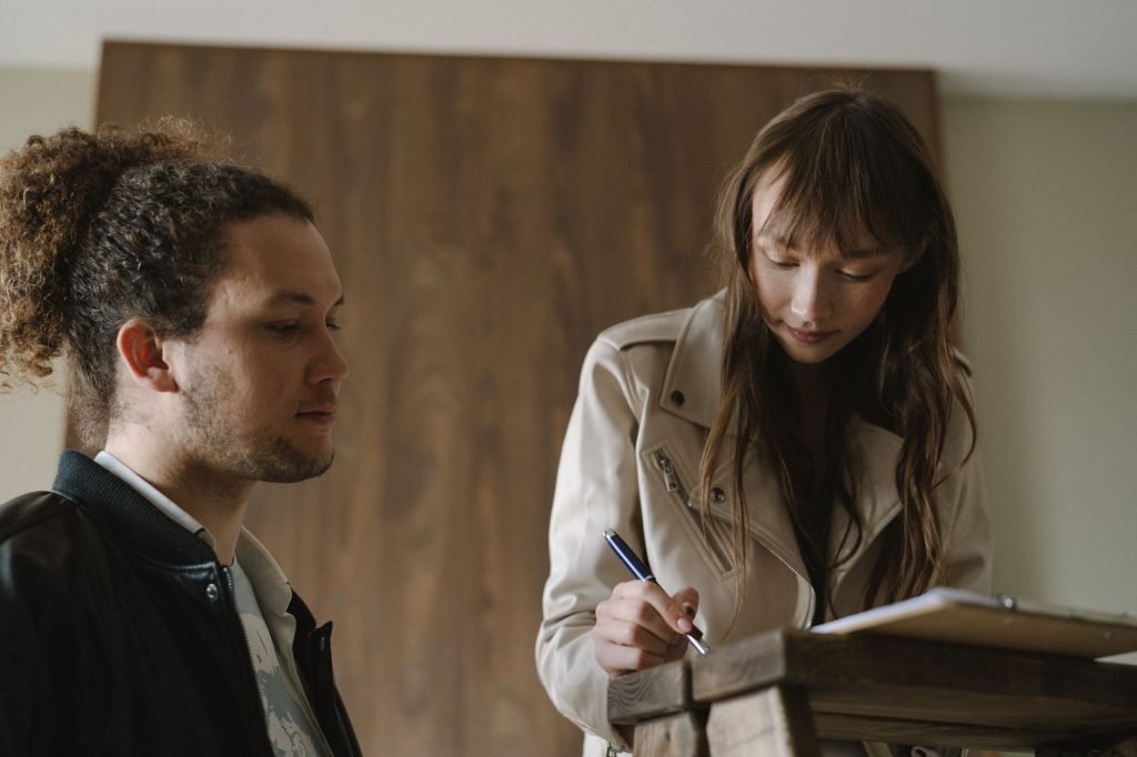 Two people reading and signing tenancy documents at a table