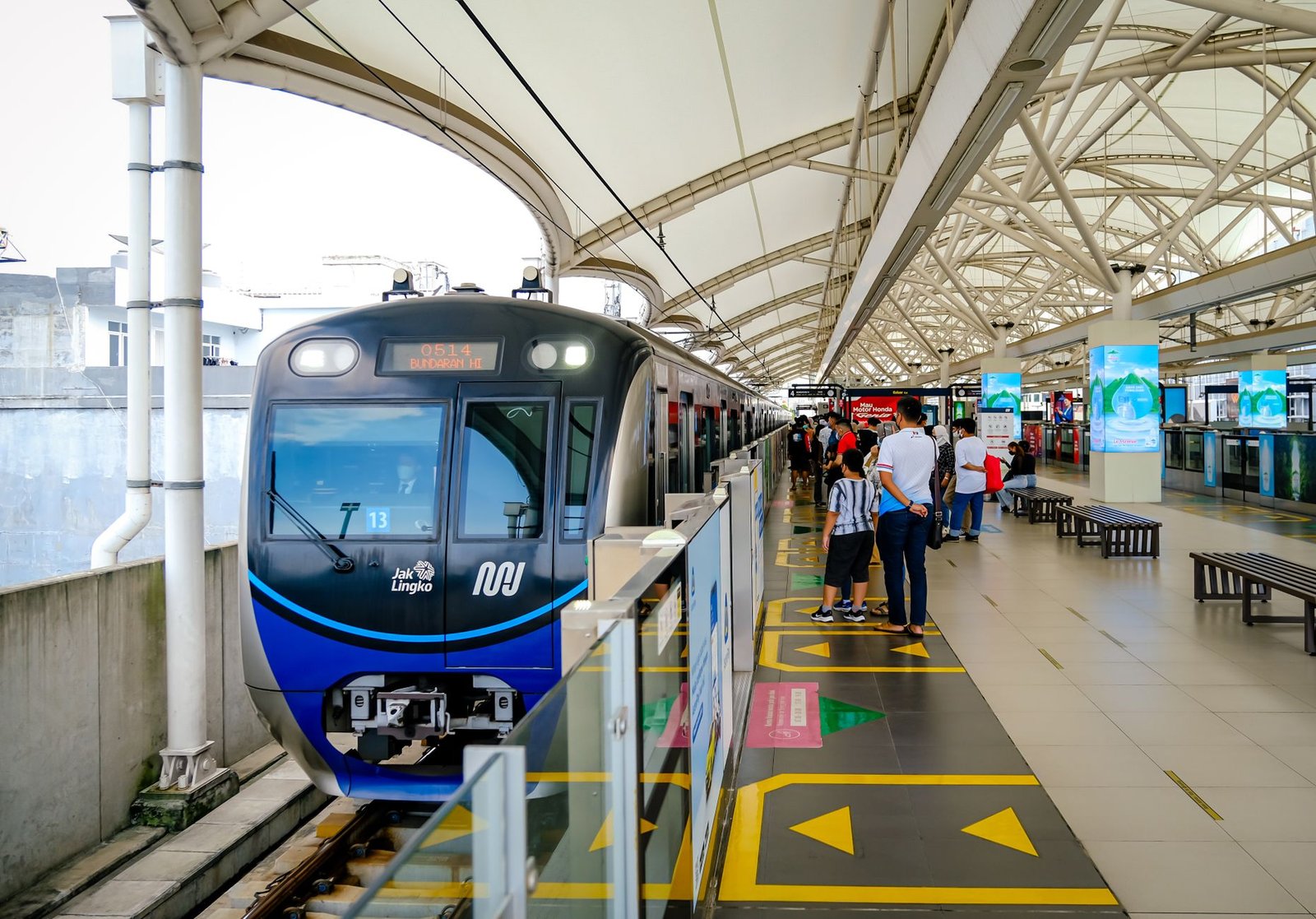 A Jakarta MRT train at a station platform with waiting commuters