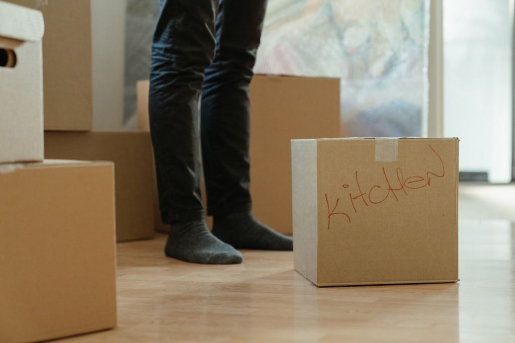Moving boxes labelled by room standing in an empty apartment