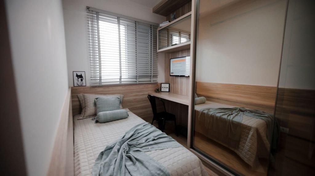 A single furnished room with one bed and a small work desk