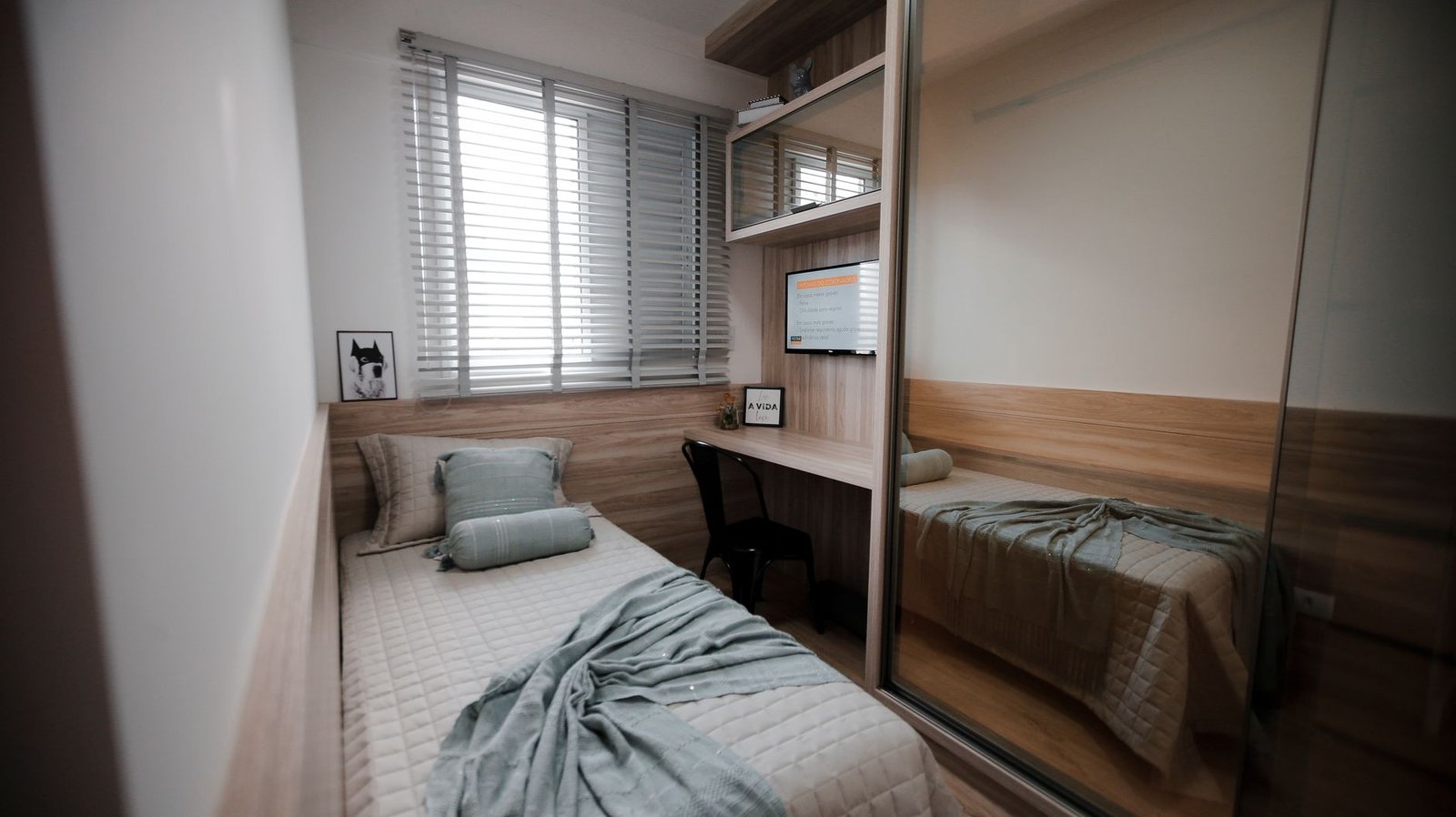 A single furnished room with one bed and a small work desk