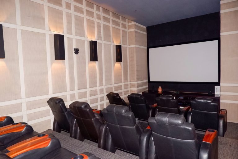 Private screening room with reclining leather seats facing a projection screen