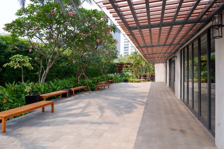 Shaded running track under the pergola, with timber benches along one side
