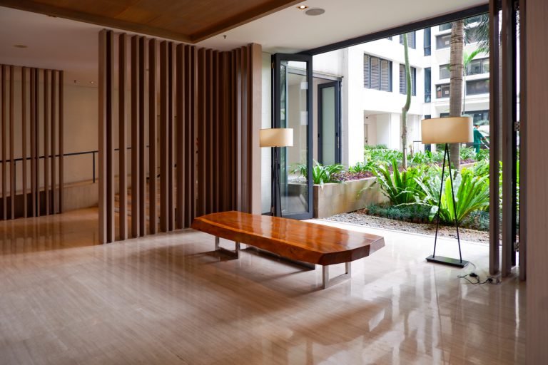 Open lounge area with a long timber bench, floor lamps and sliding screens onto the courtyard