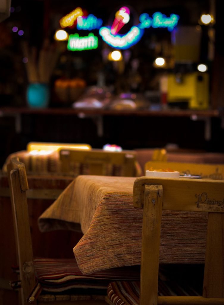 A warm restaurant interior with set tables and soft lighting
