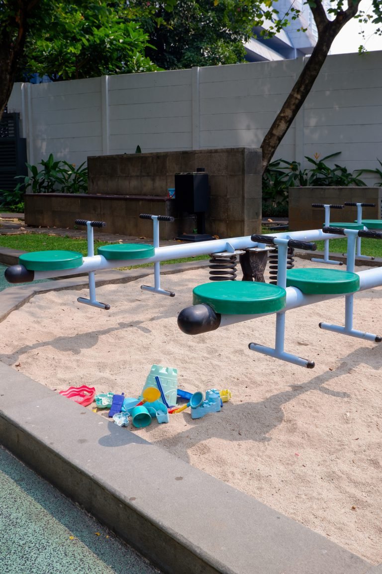 Playground sandpit with spring riders and a small roundabout