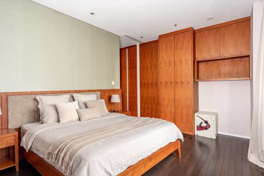 Bedroom with fitted timber wardrobes running the length of the wall beside the bed