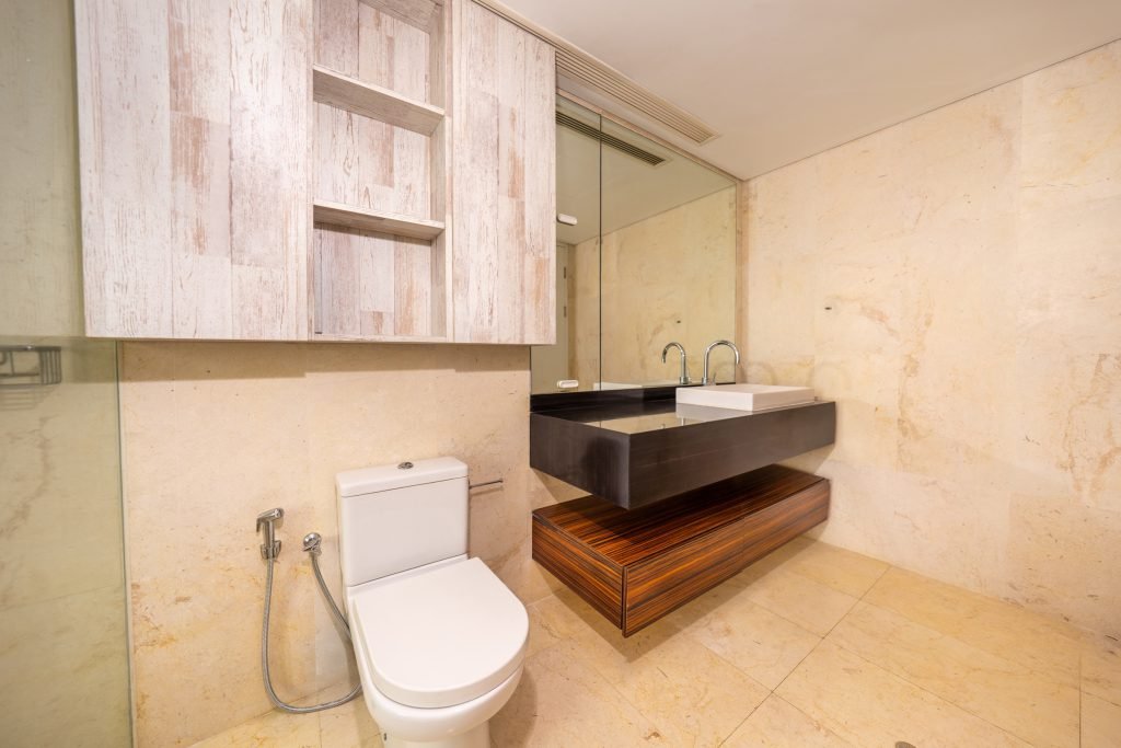 Marble bathroom with basin, mirror cabinet and toilet, shower enclosure to the right