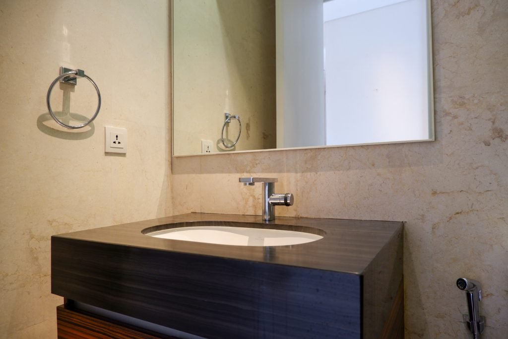 Bathroom vanity with a dark timber counter, undermount basin and wall mirror