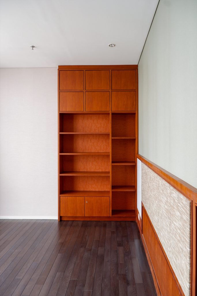 Timber shelving unit built into the bedroom wall next to the wardrobe