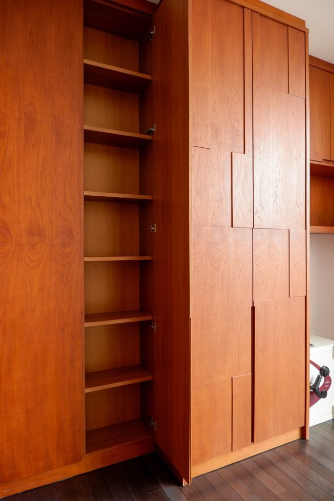 Open timber wardrobe showing hanging space and adjustable shelves