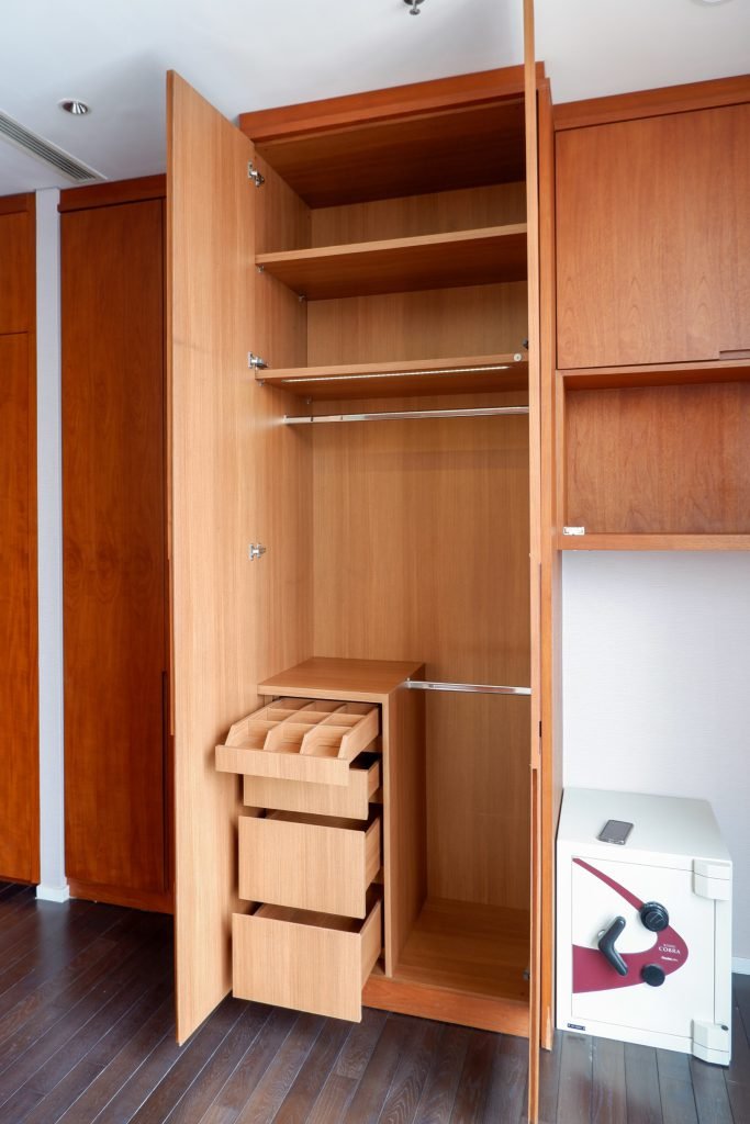 Timber wardrobe with door open, showing internal drawers and shelving