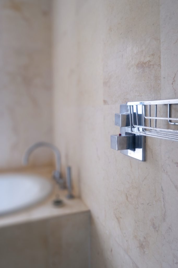 Bathroom with a wall-mounted tap over a stone basin set in a marble surround