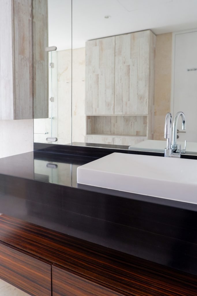Bathroom vanity with a rectangular basin, dark timber counter and large mirror